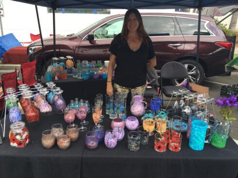 A woman standing next to a table filled with candles.