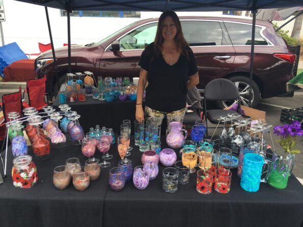 A woman standing next to a table filled with candles.