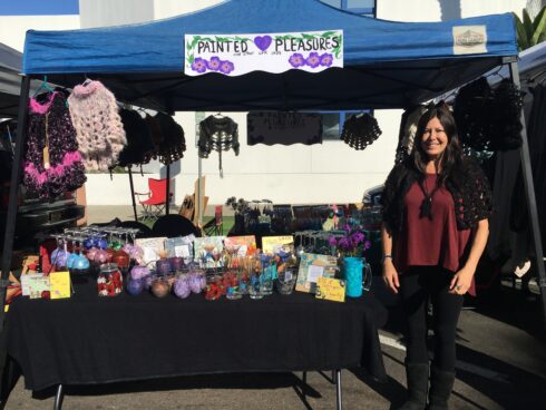 A woman standing next to a table with items on it.