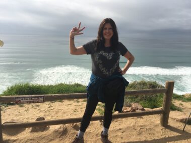 A woman standing on top of a sandy beach.