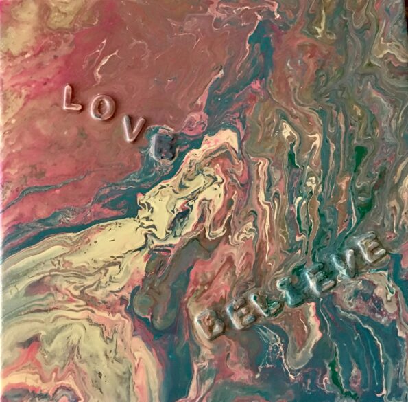 A painting of the words love and believe on it.
