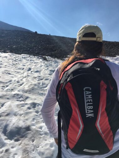A person with a backpack walking in the snow.