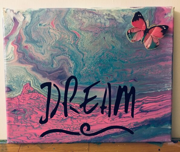 A butterfly sitting on top of a painting.